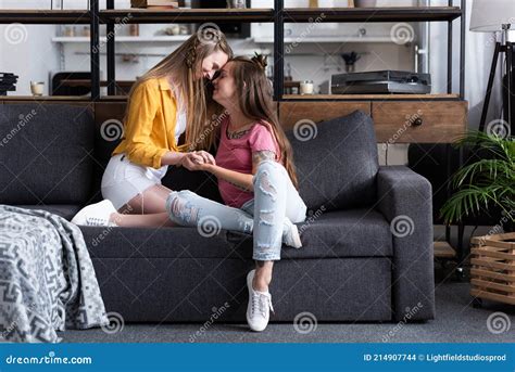 Duas Lésbicas Sorridentes De Mãos Dadas Enquanto Sentavam No Sofá Na
