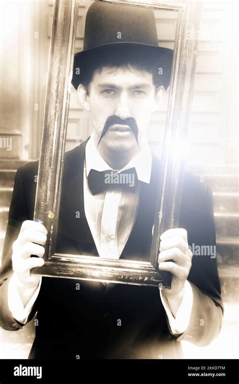 Vintage Man Looks Through A Retro Picture Frame From Yesterday In A Bygone Moment Representing