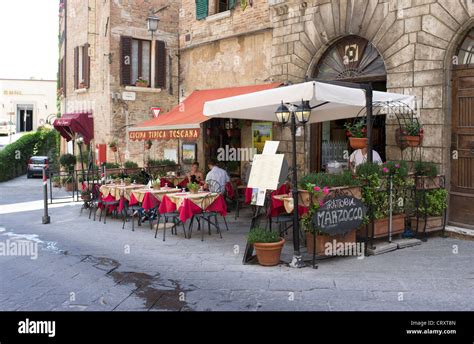 People Sat At A Table Outside Of Italian Restaurant In Montepulciano