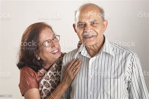 Woman Gazes Lovingly At Her Husband As She Hugs His Shoulder Stock