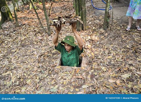 Tour Guide Demonstrating How A Vietcong Hide Into The Cu Chi Tunnels