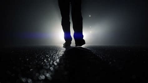 Low Angle View Of Man Feet Walking Into Dark Night Mystical Fog
