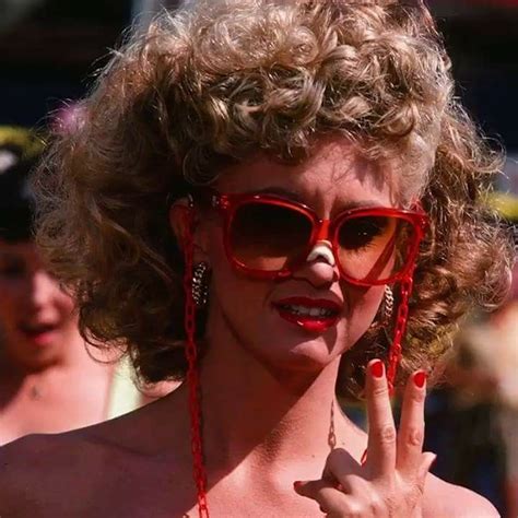 A Woman Wearing Red Sunglasses Making The Peace Sign