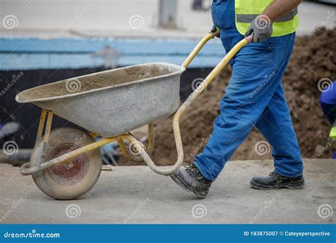 Details With A Construction Worker Pushing A Wheelbarrow On A