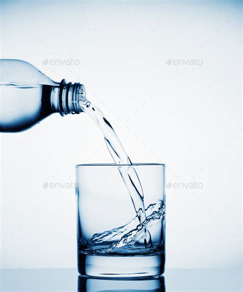 Water Pouring Into A Wide Glass From A Bottle Stock Photo By Alexlukin