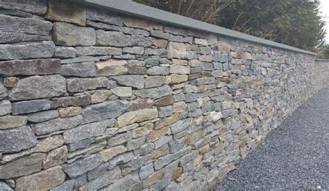 Stone Facing Applied To Retaining Wall With Bluestone Caps Patio