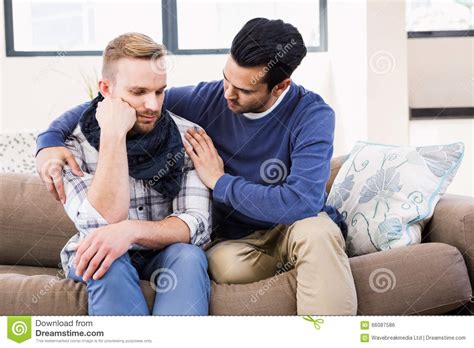 Gay Couple Comforting Each Other On The Couch Stock Photo Image Of