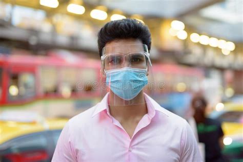 Face Of Young Indian Businessman With Mask And Face Shield In The City