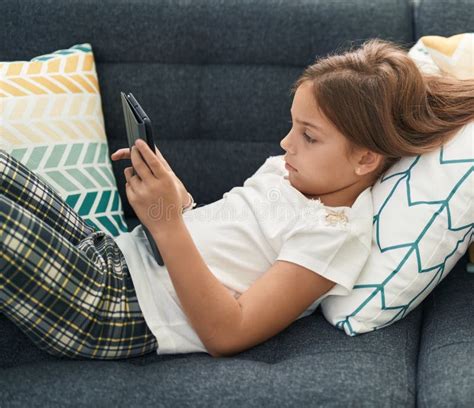 Adorable Hispanic Girl Using Touchpad Lying On Sofa At Home Stock Image Image Of Device Sofa