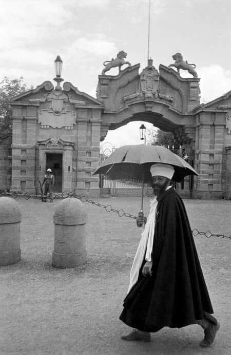 Black And White Photograph Of A Man With An Umbrella In Front Of A