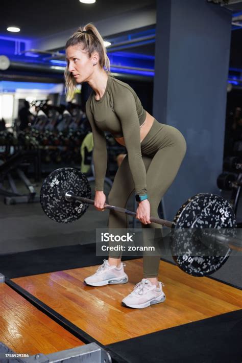 Strong Woman Bending Forward And Lifting Barbell In The Gym Stock Photo