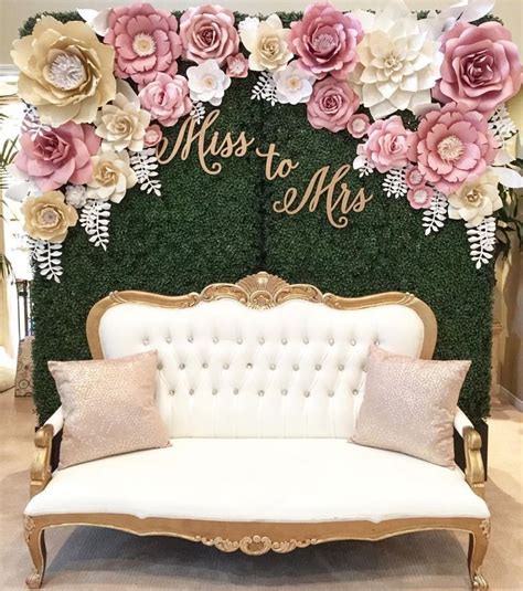 bridal shower photo booth inspo a vintage couch with a grass and flower backdrop bridal shower