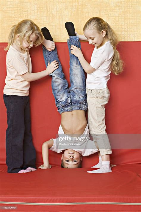 Two Girls Holding A Boy Upside Down High Res Stock Photo Getty Images