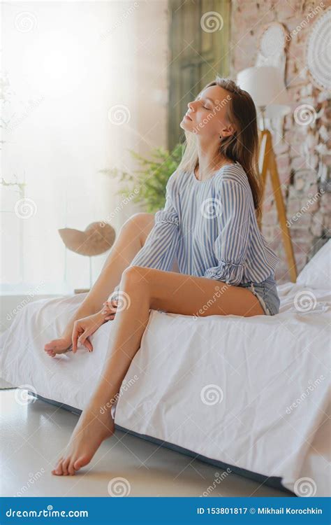 Young Cute Girl Sitting On Bed Beauty Comfort And Relaxation Stock