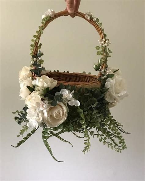 A Basket With Flowers And Greenery Hanging From It