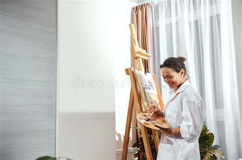Pintora Mujer Con Camisa Blanca Parada Frente Al Pensamiento Del Caballete Y Mirando El Lienzo