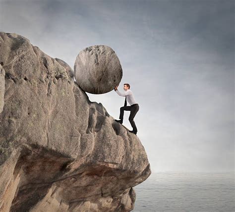 Man Pushing Rock Up Hill Stock Photos Pictures And Royalty Free Images