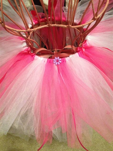 A Pink And White Tutule Is Sitting In A Basket