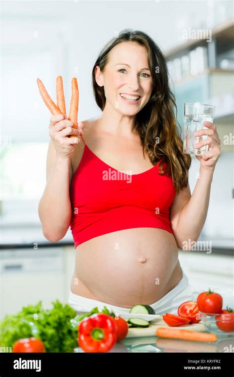 Schwangere Frau Mit Gemüse Und Wasserglas In Der Küche Pregnant Woman With Vegetables And A