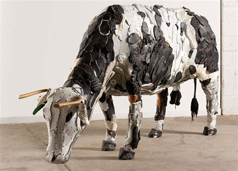 A Sculpture Of A Cow Made Out Of Paper Machs Is Standing On The Concrete
