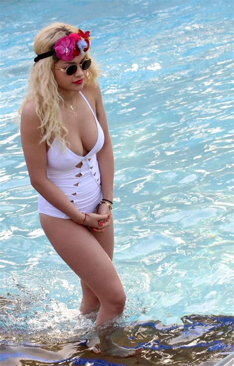 rita ora busty wearing a white slightly see through swimsuit at the pool in duba porn pictures