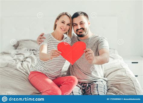 feliz matrimonio fuerte feliz pareja divertida enamorada sosteniendo el corazón del papel rojo