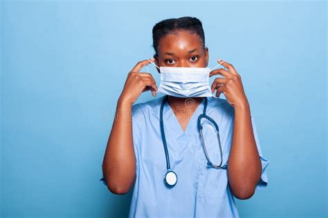 African American Practitioner Nurse Putting Protective Face Mask Stock