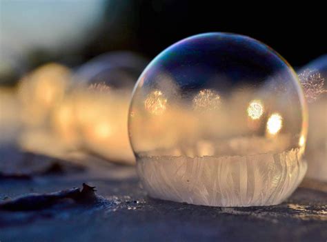 A Close Up Of A Soap Bubble On The Ground With Other Bubbles In The