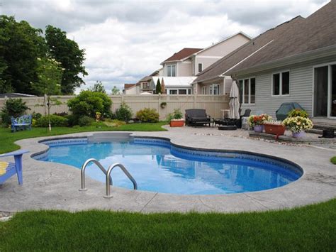 A Backyard With A Swimming Pool And Lawn Furniture