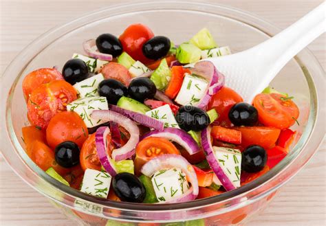 Transparent Glass Bowl With Greek Salad And Plastic Spoon Stock Photo