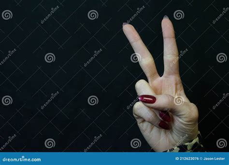 Woman S Hand Giving Peace Sign With Black Background Stock Photo