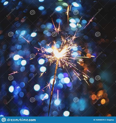 New Year Background With Sparkler And Christmas Light Bokeh Stock