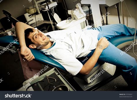 Young Man A Dentist Or A Patient Lies On The Chair In The Dentists Office In A Very Relaxed