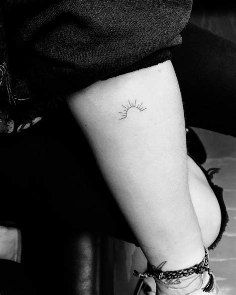 A Small Sun Tattoo On The Arm