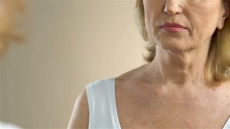 Mature Woman Heavily Sighing Looking At Her Wrinkled And Sagging Skin