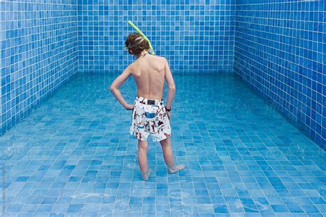Boy In Bathing Suit And Snorkel Set Standing In Shallow Water Of A