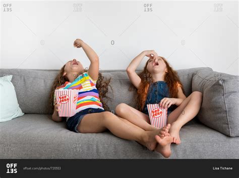 Babe Girls On Gray Sofa Eating Pop Corn Stock Photo OFFSET