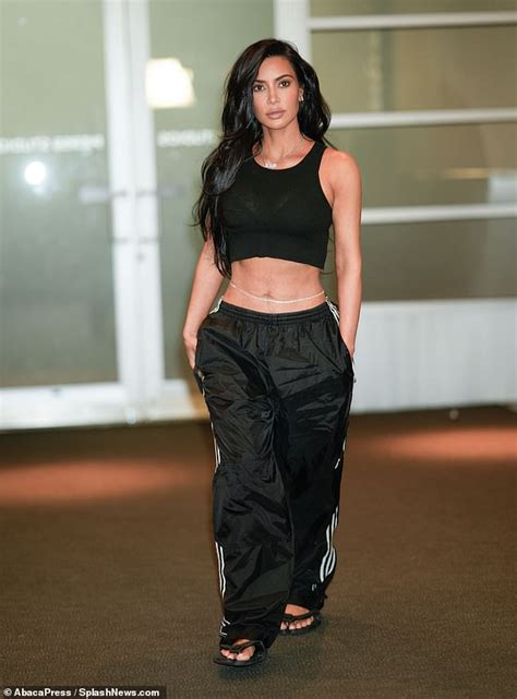 kim kardashian shows off her well defined midriff in a crop top track pants and a belly chain