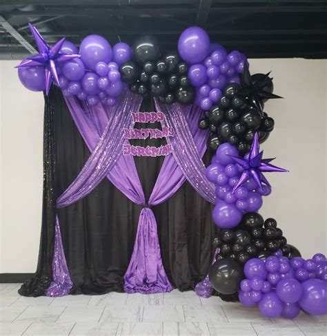 purple and black balloons are on display at a party