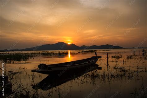 Beautiful Sunset Sky And Wood Boat Floating In Bangpra Water Reservoir