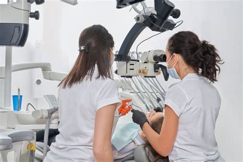 Female Dentists Diagnosing Patient In Dentistry Clinic Stock Image