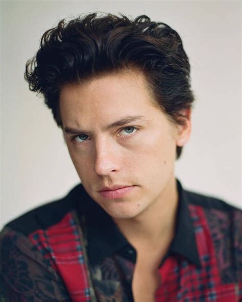 A Close Up Of A Person Wearing A Plaid Shirt And Looking At The Camera