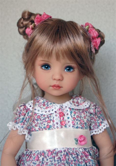 A Doll With Blonde Hair And Blue Eyes Is Wearing A Pink Flowered Dress