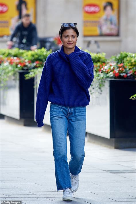 Emma Raducanu smiles as she dons a chunky blue sweater and jeans for