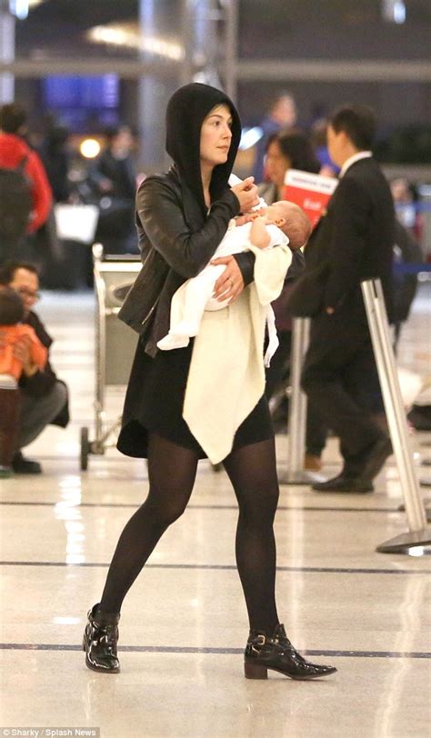 Rosamund Pike Keeps A Low Profile As She Cradles Her Son At Lax Airport