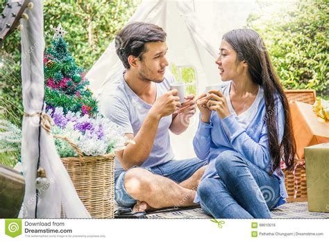 Young Couple Drinking Coffee With A Present In The Park Stock Photo