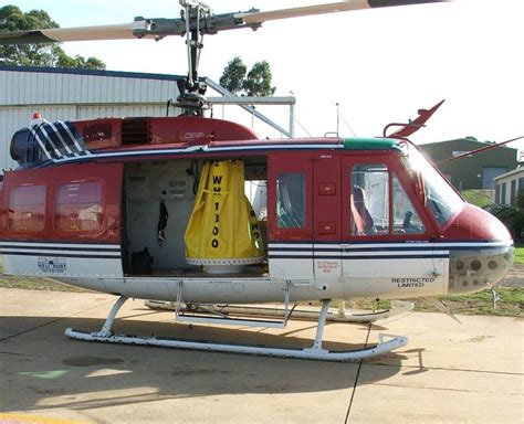 A Red And White Helicopter Parked In Front Of A Building