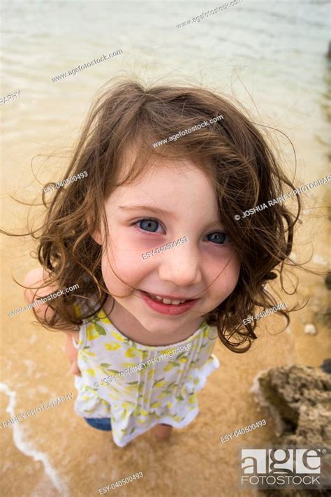 Portrait Of A Young Girl Standing In The Water At The Beach While On