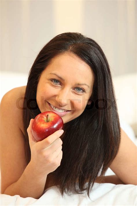 Naked Woman Eating An Apple In Bed Stock Image Colourbox