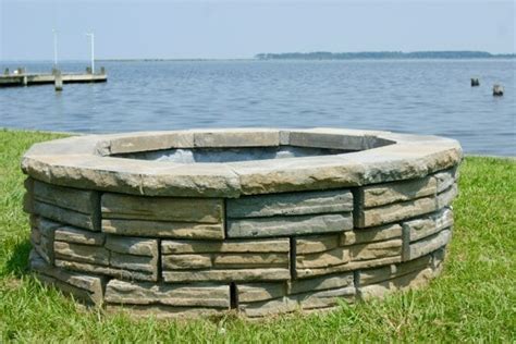 The chunky black mexican beach pebbles surrounding the flames costing well under $100, this square diy fire pit is a simple and stylish backyard design element constructed from cement wall blocks laid in a bed of sand. Remodelaholic | DIY Retaining Wall Block Fire Pit